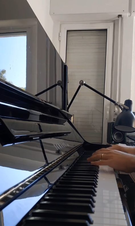 As mãos do João Eiró ao piano, sob um candeeiro