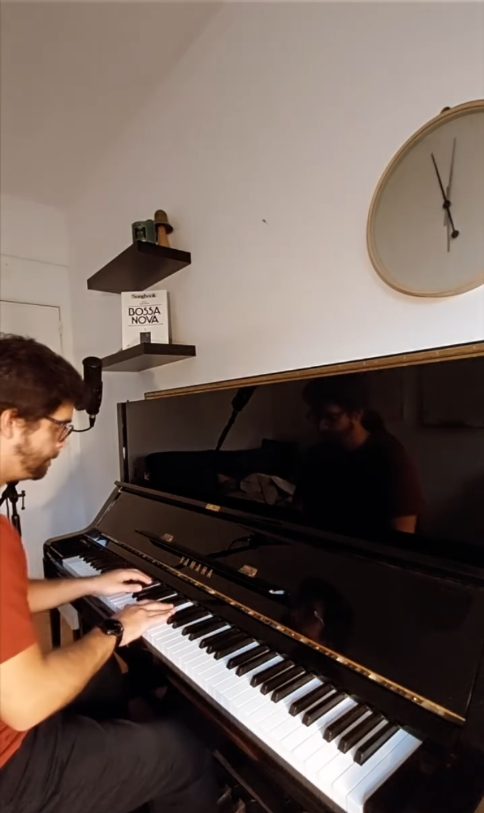 João Eiró a tocar piano por baixo de um relógio de parede