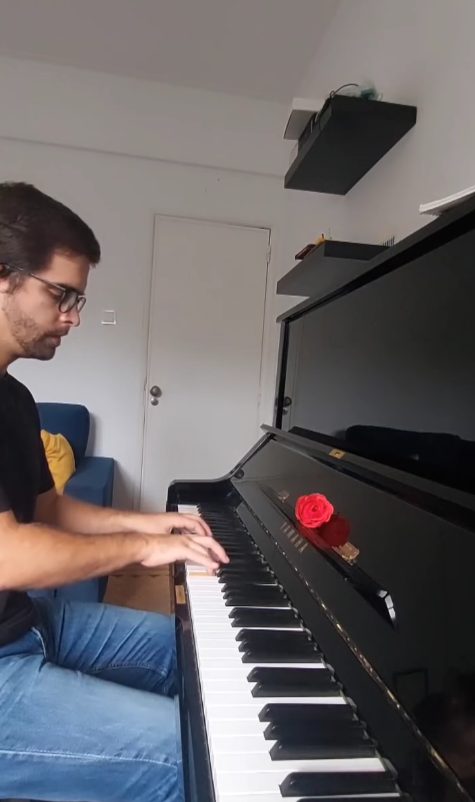 João Eiró a tocar piano, com uma rosa vermelha na tampa